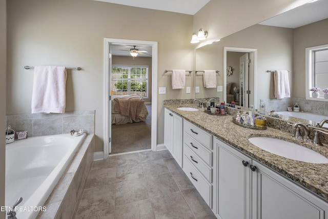 ensuite bathroom with double vanity, ensuite bath, a sink, and ceiling fan