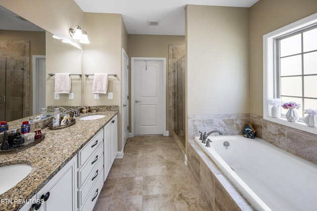 bathroom featuring a sink, double vanity, a shower stall, visible vents, and a garden tub