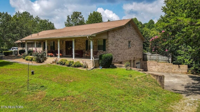 ranch-style house featuring an attached garage, a porch, brick siding, a front lawn, and driveway