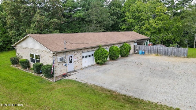 view of front of property featuring an attached garage, driveway, a front yard, and fence