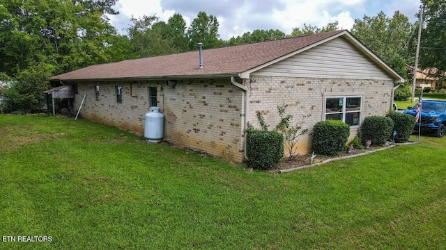 view of side of property with a yard and brick siding