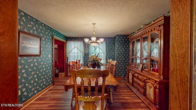 dining space featuring wallpapered walls, wood finished floors, a notable chandelier, and baseboards