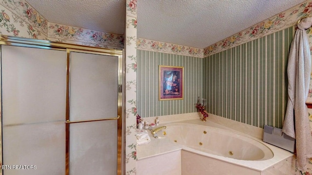 bathroom featuring a shower stall, a jetted tub, a textured ceiling, and wallpapered walls
