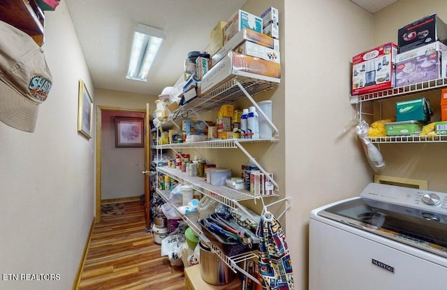 clothes washing area featuring washer / clothes dryer, laundry area, and wood finished floors