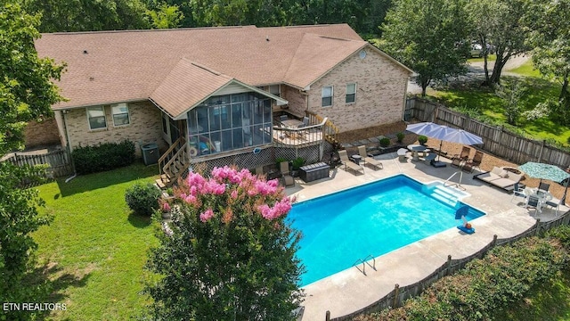 view of swimming pool with a sunroom, a lawn, a fenced backyard, an outdoor living space, and a patio