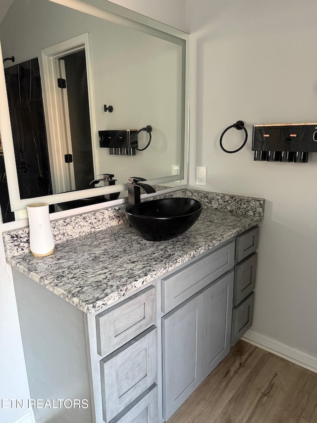 bathroom with vanity, baseboards, and wood finished floors