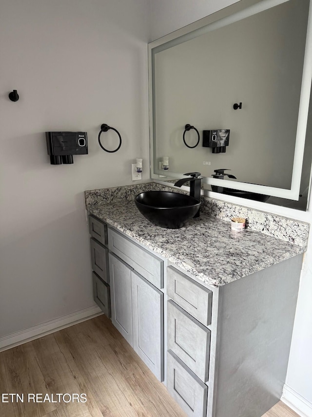 bathroom featuring baseboards, vanity, and wood finished floors