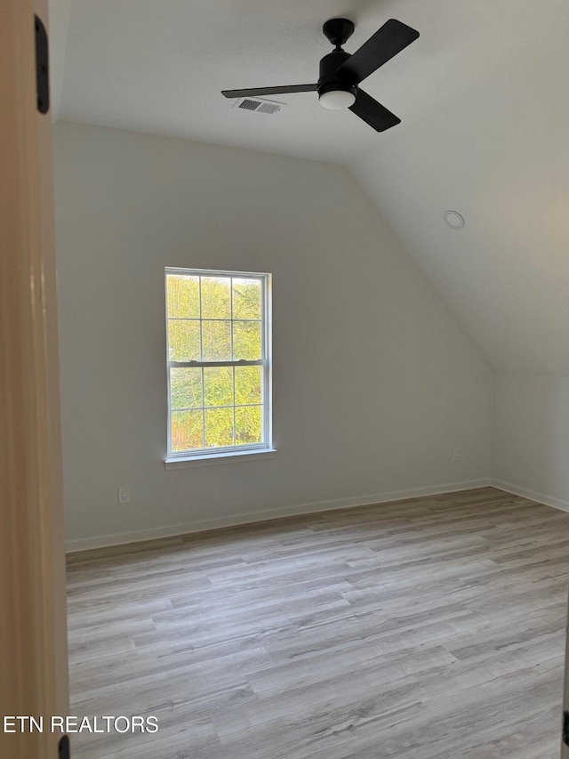 additional living space featuring visible vents, a ceiling fan, wood finished floors, and vaulted ceiling