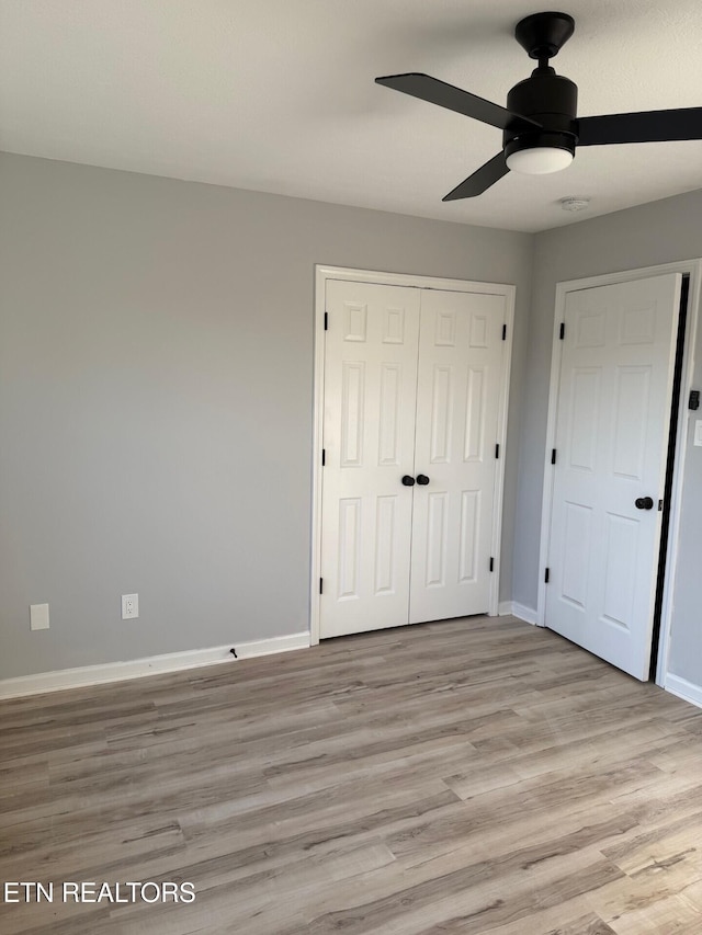 unfurnished bedroom with a closet, baseboards, ceiling fan, and light wood-style floors