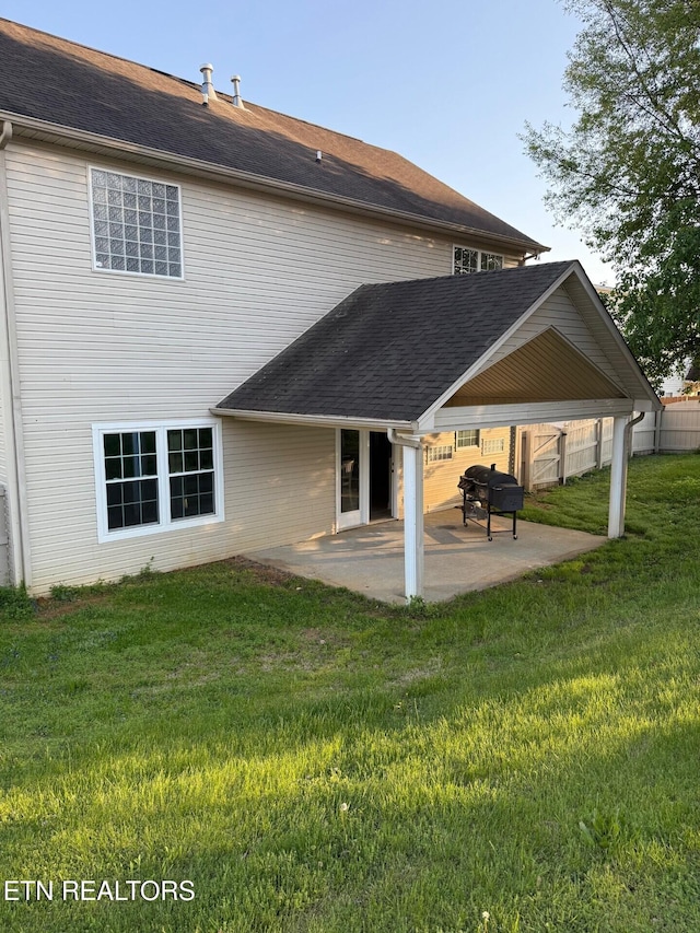 rear view of house featuring a patio, fence, and a lawn