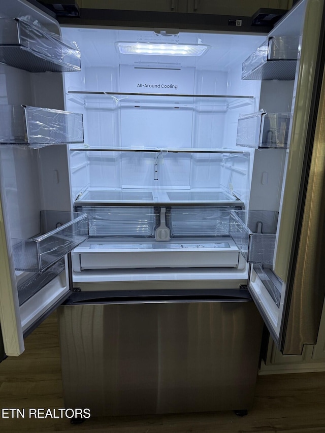 room details featuring refrigerator and wood finished floors