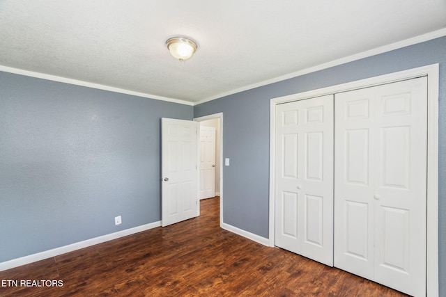 369 Robertsville Rd, Oak Ridge, TN 37830 - unfurnished bedroom featuring crown molding, dark wood-style flooring, baseboards, and a closet