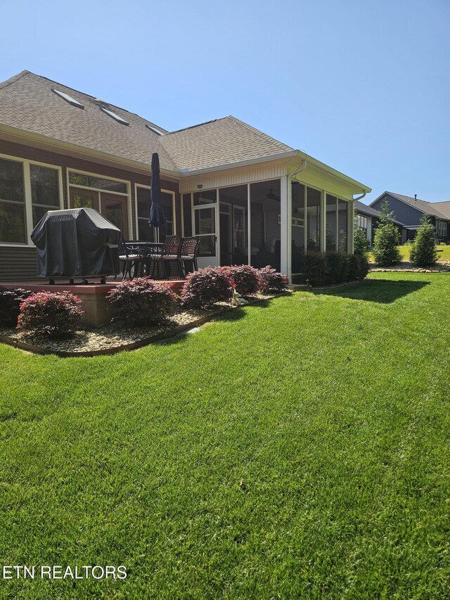 169 Dudi Trl, Vonore, TN 37885 - back of property featuring roof with shingles, a sunroom, and a yard