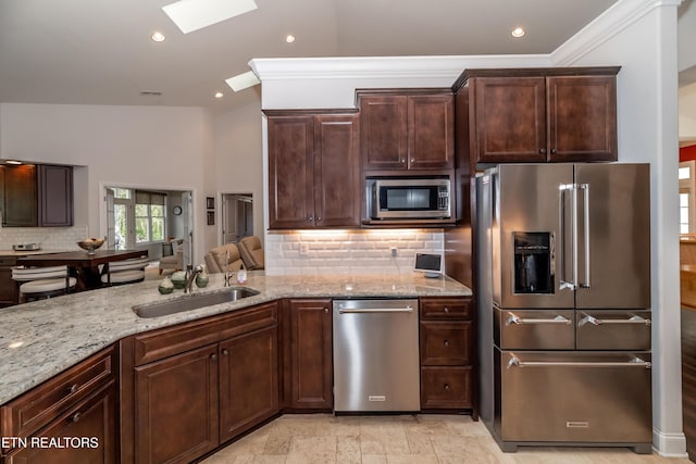 169 Dudi Trl, Vonore, TN 37885 - kitchen featuring a sink, a skylight, backsplash, appliances with stainless steel finishes, and light stone countertops