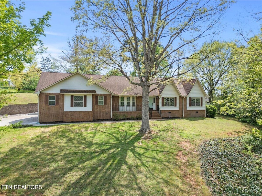 view of front of home featuring crawl space, a shingled roof, a front yard, and brick siding