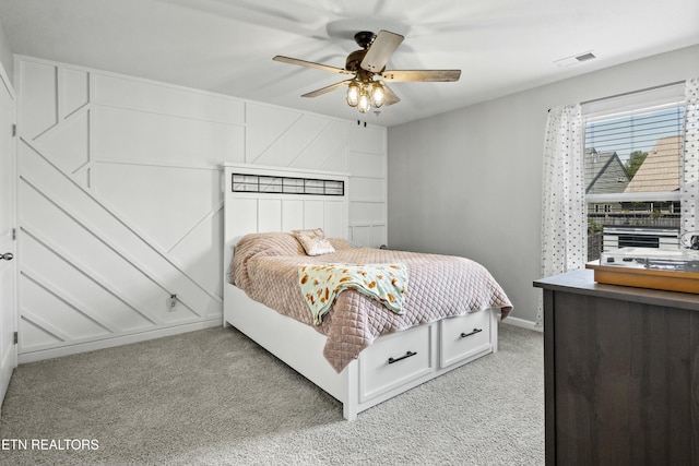 bedroom featuring ceiling fan, visible vents, baseboards, and light carpet