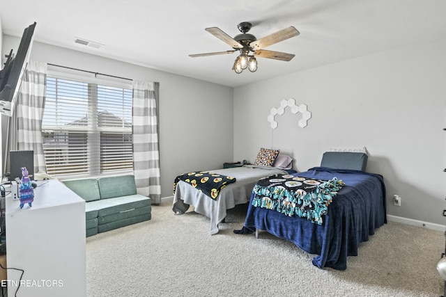 bedroom with baseboards, a ceiling fan, visible vents, and carpet