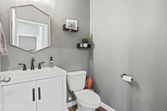 bathroom featuring wood finished floors, vanity, and toilet
