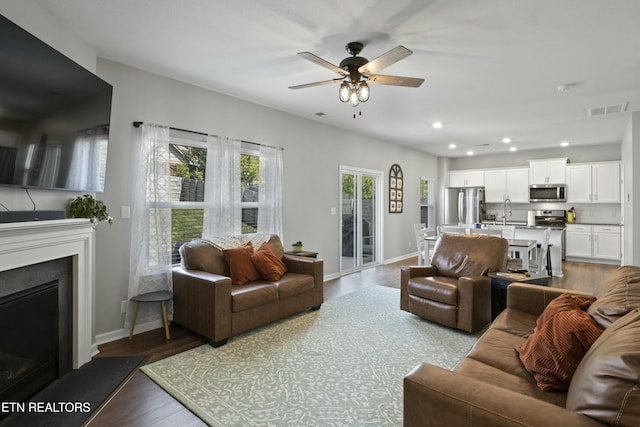 living area with visible vents, baseboards, recessed lighting, and a ceiling fan