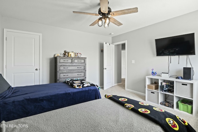 carpeted bedroom with a ceiling fan and baseboards