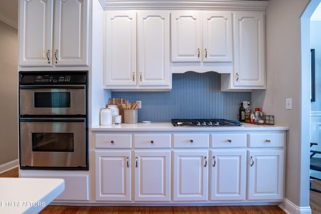 kitchen with white cabinets, appliances with stainless steel finishes, and tasteful backsplash