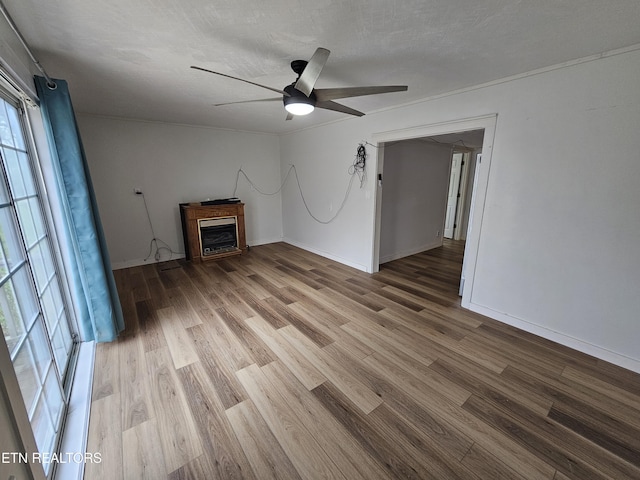 1009 Roysden Rd, Jamestown, TN 38556 - unfurnished living room featuring a fireplace, baseboards, a ceiling fan, and wood finished floors