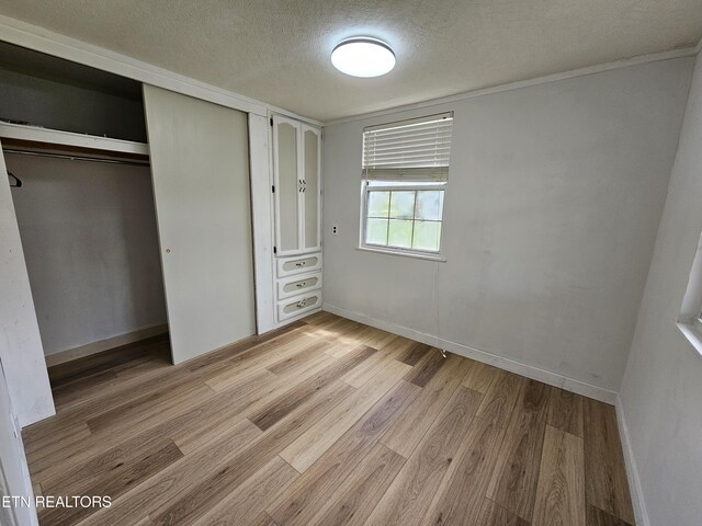 1009 Roysden Rd, Jamestown, TN 38556 - unfurnished bedroom featuring a closet, baseboards, wood finished floors, and a textured ceiling