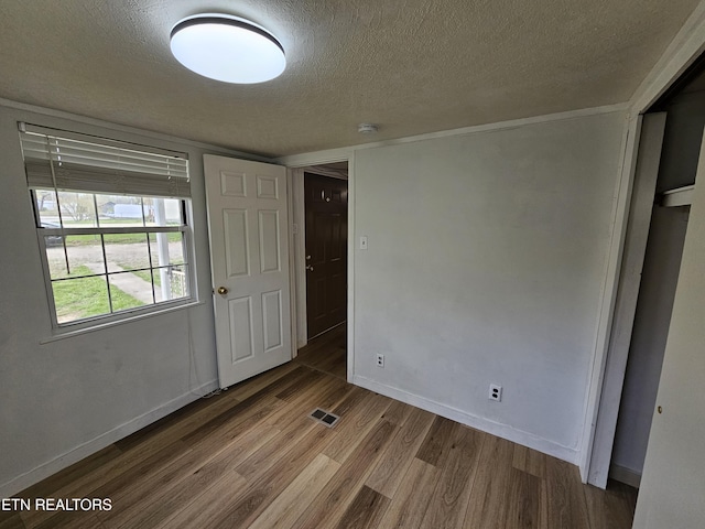 1009 Roysden Rd, Jamestown, TN 38556 - unfurnished bedroom with visible vents, a textured ceiling, baseboards, and wood finished floors