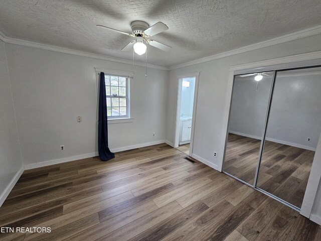 1009 Roysden Rd, Jamestown, TN 38556 - unfurnished bedroom with baseboards, a textured ceiling, crown molding, visible vents, and wood finished floors