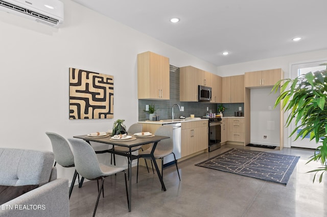 105 E Oldham Ave Unit 103, Knoxville, TN 37917 - kitchen featuring appliances with stainless steel finishes, light brown cabinetry, finished concrete flooring, light countertops, and a wall mounted air conditioner