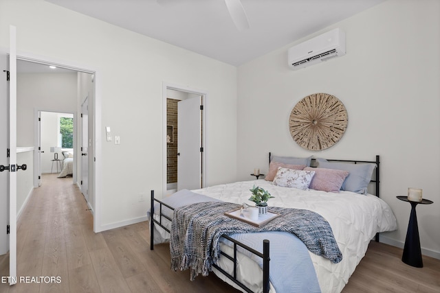 105 E Oldham Ave Unit 103, Knoxville, TN 37917 - bedroom with a wall mounted AC, light wood-style floors, baseboards, and ceiling fan