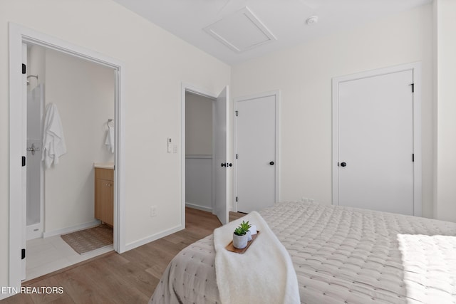 105 E Oldham Ave Unit 103, Knoxville, TN 37917 - bedroom with attic access, wood finished floors, baseboards, and connected bathroom