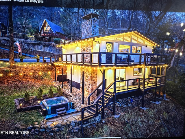 back of property with stone siding and a deck