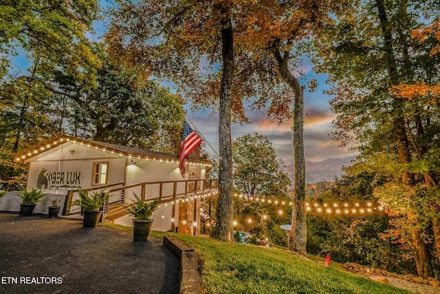 yard at dusk featuring a wooden deck