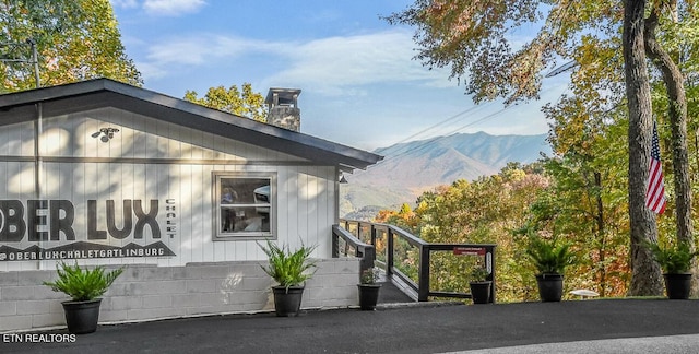 view of home's exterior with a chimney and a mountain view