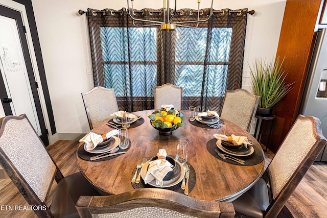 dining area with baseboards and wood finished floors