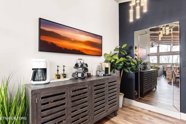 bar featuring ceiling fan, a dry bar, and wood finished floors