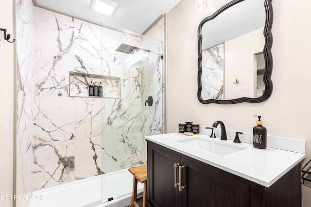 full bath featuring vanity and a marble finish shower