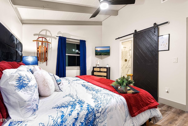 bedroom featuring a barn door, a ceiling fan, wood finished floors, lofted ceiling with beams, and baseboards