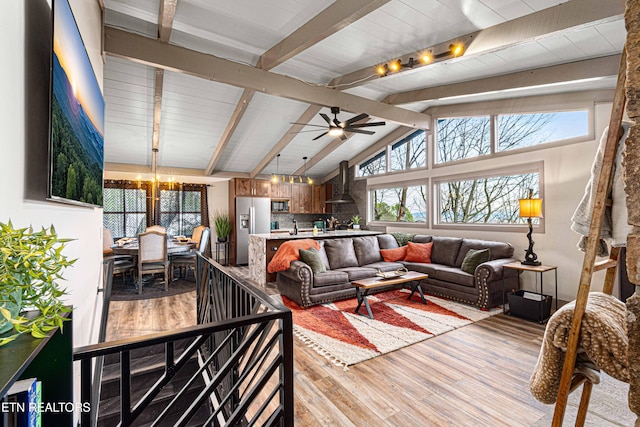 living room with light wood finished floors, lofted ceiling with beams, and ceiling fan with notable chandelier