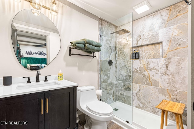 full bathroom with a tile shower, toilet, and vanity