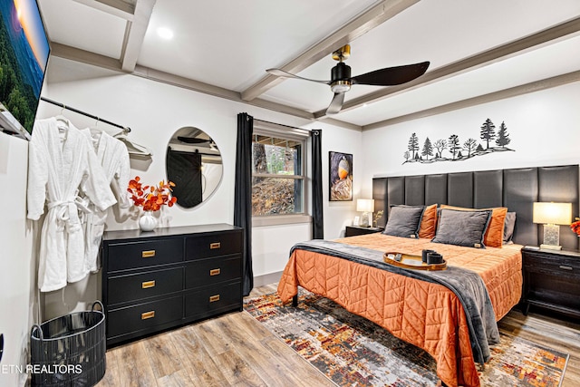 bedroom featuring ceiling fan, beamed ceiling, and light wood finished floors