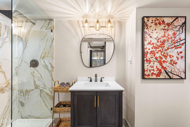 bathroom with vanity, a marble finish shower, and an inviting chandelier