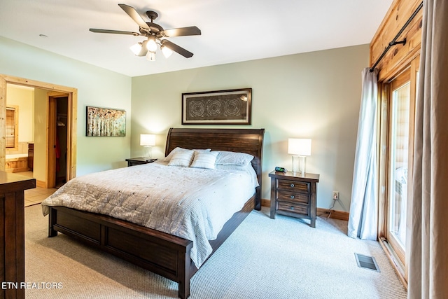bedroom with light colored carpet, ensuite bath, a ceiling fan, baseboards, and visible vents