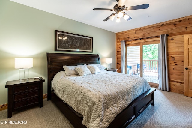 bedroom featuring ceiling fan, access to exterior, wood walls, baseboards, and carpet flooring