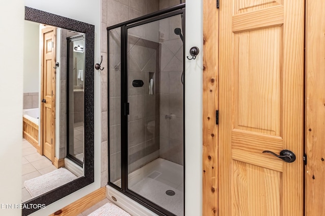 full bath with a garden tub, tile patterned flooring, and a shower stall