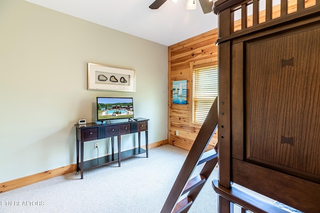 bedroom with carpet floors, baseboards, and wooden walls