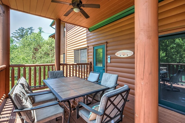 wooden terrace featuring outdoor dining area and ceiling fan