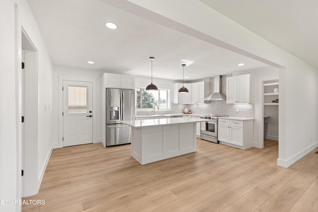 5911 Roberts Rd, Corryton, TN 37721 - kitchen featuring white cabinetry, wall chimney range hood, light countertops, a kitchen island, and appliances with stainless steel finishes