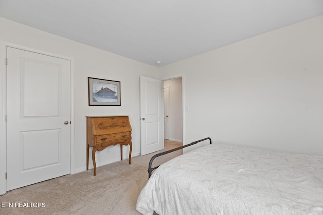 bedroom featuring light carpet and baseboards